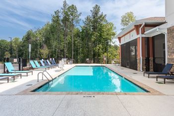 A Pool Surrounded By Trees at The Aster Apartments, Cary, NC